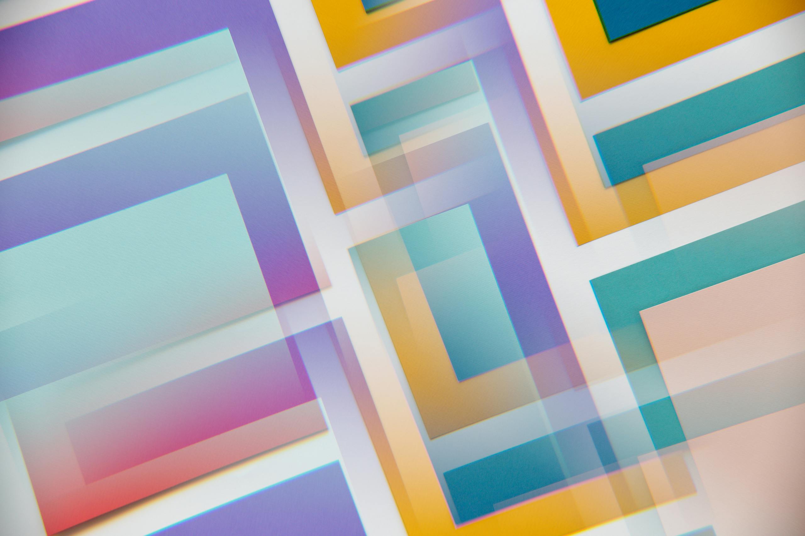 A dynamic blend of overlapping pastel geometric shapes creating a vibrant abstract design.