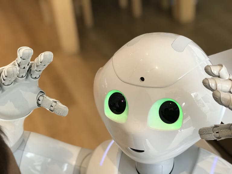 A futuristic humanoid robot with glowing green eyes in a modern setting.